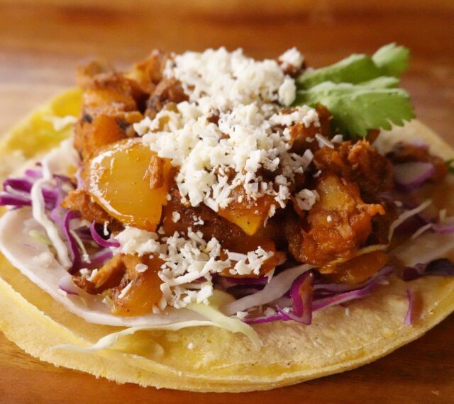 Our newest Taco of the Month, The Puebla. Our take on Tacos Al Pastor. A corn tortilla topped with cabbage, smoked pork, pineapple, red onion, chile marinade, cotija, and cilantro.