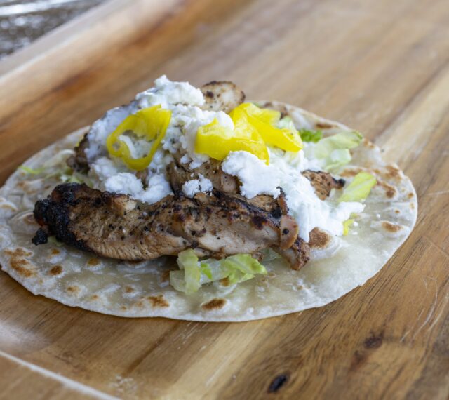 Our Taco of the Month. A flour tortilla with romaine, Greek-marinated grilled chicken, house-made tzatziki sauce, crumbled feta cheese, and pepperoncini.